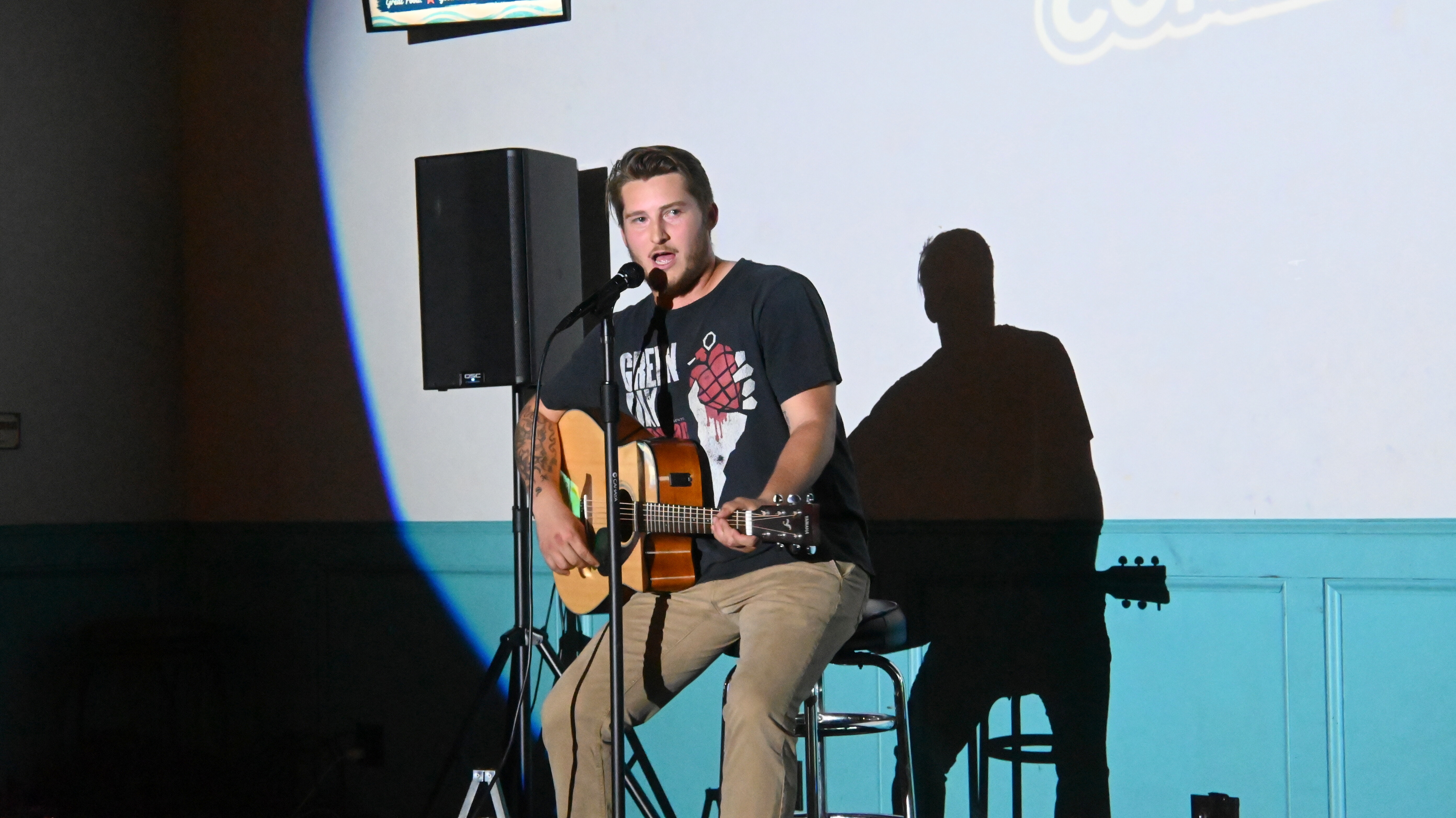 Comedian playing guitar and singing at Ballyhoos