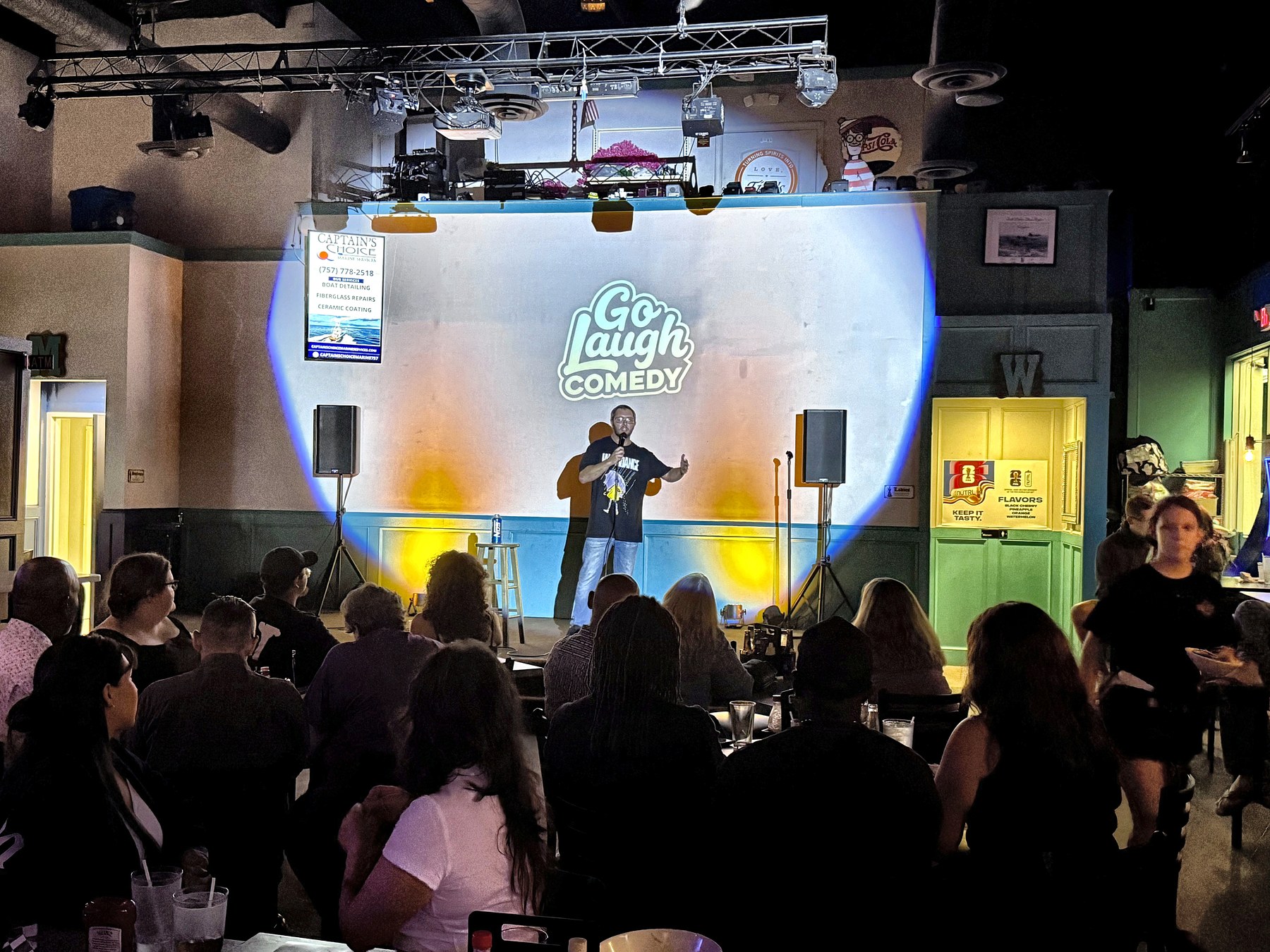 Audience watching a comedian on stage at Ballyhoos