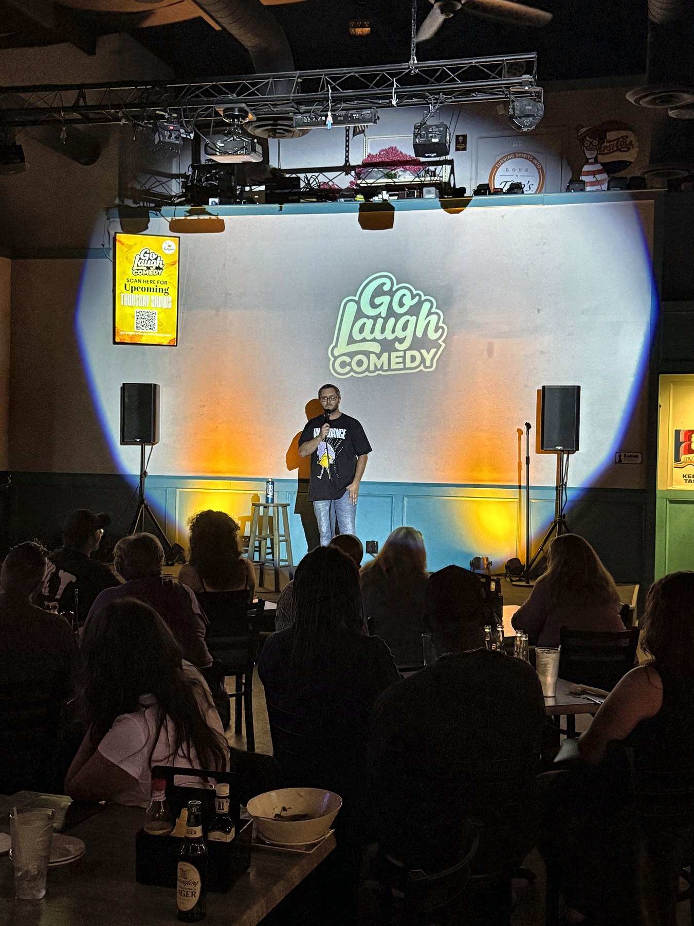 Comedian performing on stage at Go Laugh Comedy night at Ballyhoos