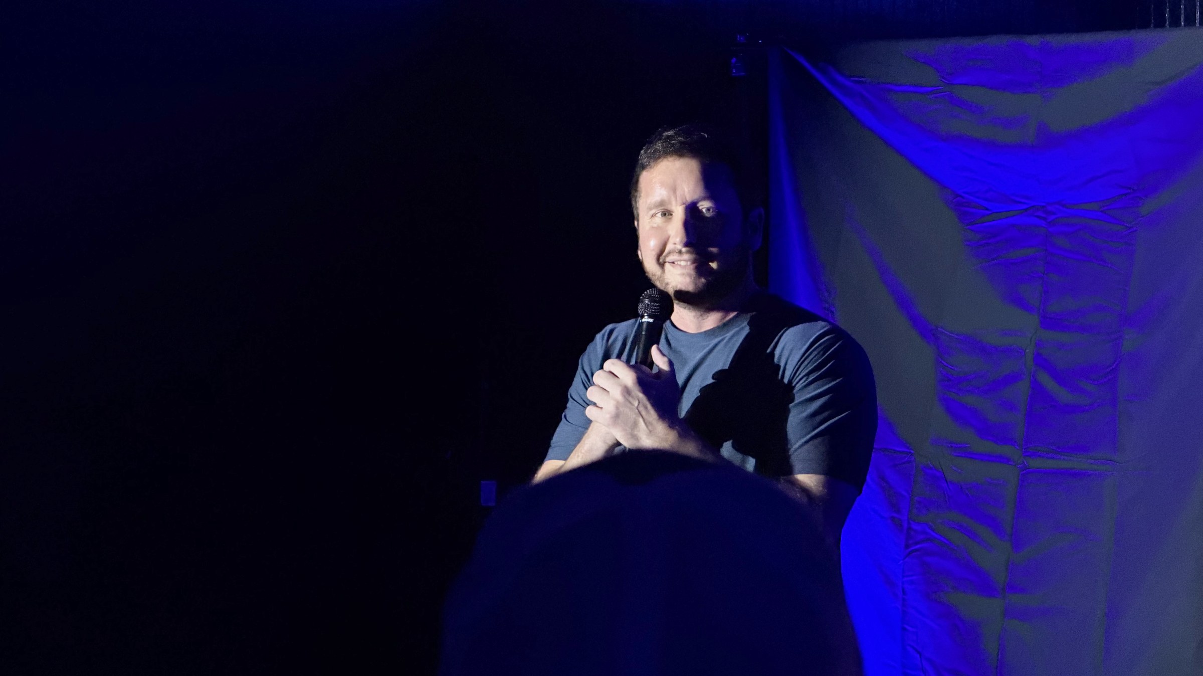 Comedian performing on stage at LauraLi's