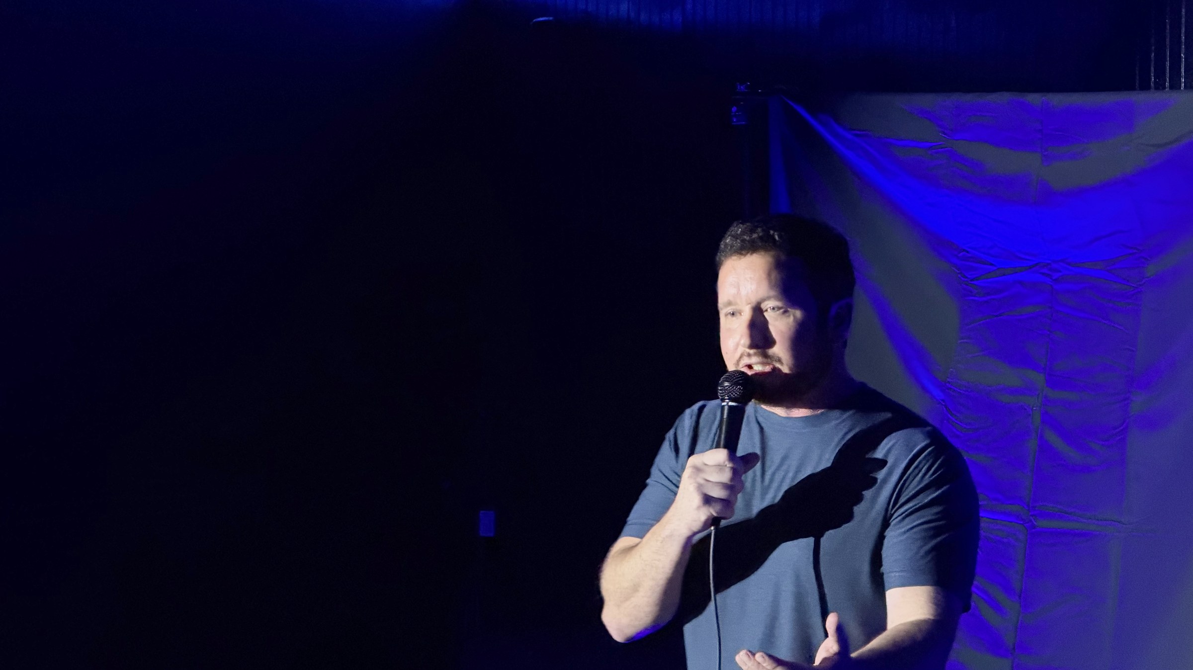 Comedian performing on stage at LauraLi's