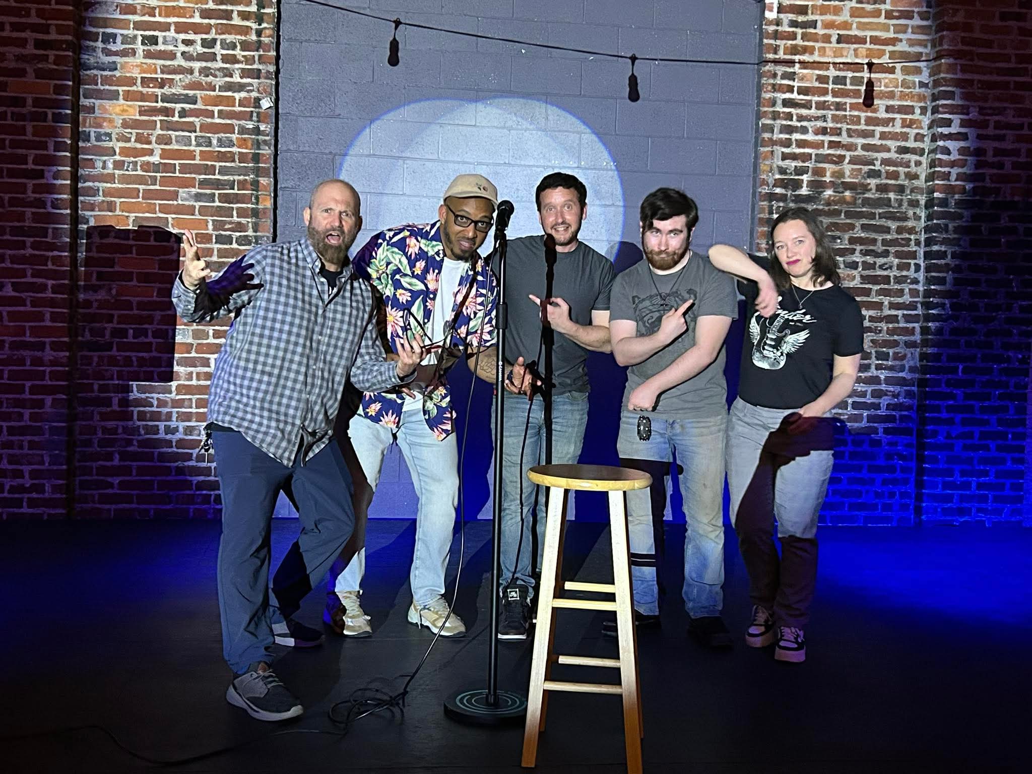 Comedians posing together on stage at Maker's Craft Brewery