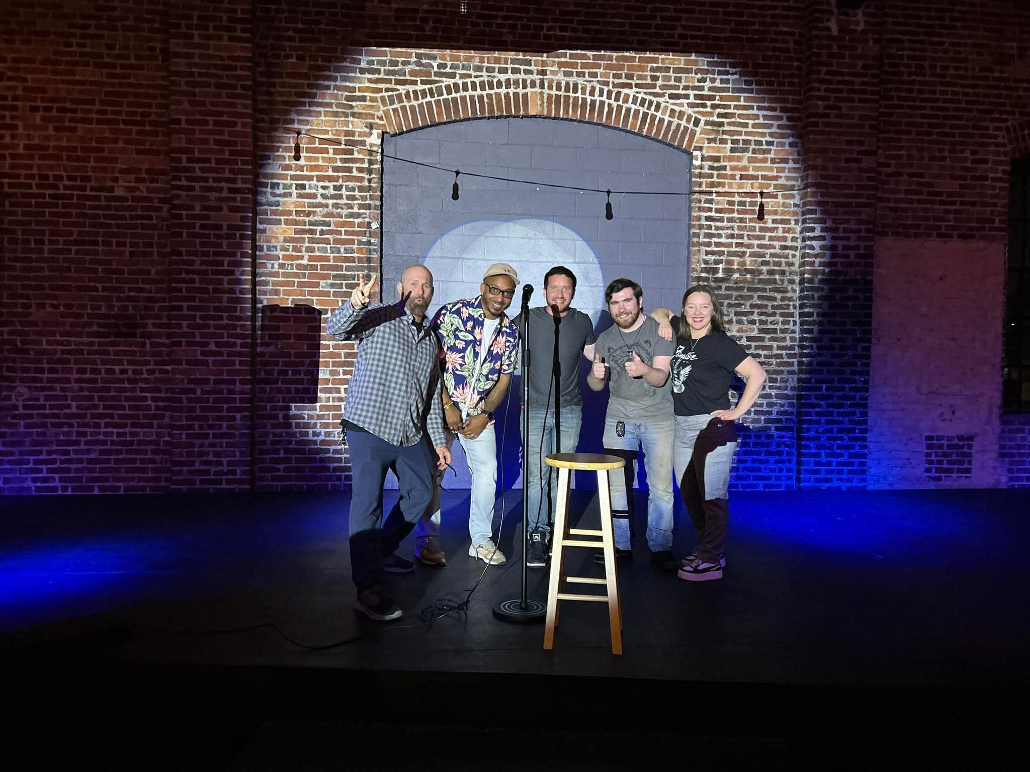 Comedians posing together on stage at Maker's Craft Brewery